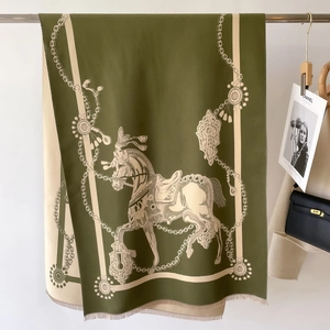 Detalle de estampado ecuestre en bufanda de cachemira oliva con flecos y motivo de cadena