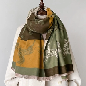 Detail of zebra pattern thick scarf featuring patchwork color blocks and tassel edges