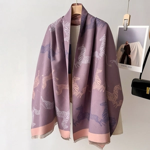 Grey-purple zebra print scarf with pink color blocks and fringe on wooden hanger