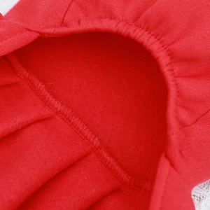 Macro view of warm red knit pet clothing with thick soft fleece lining and durable stitching