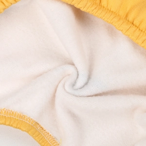 Gros plan sur la doublure polaire blanche et le bord-côte jaune d'un pyjama pour animaux
