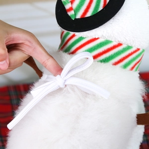 Detailed view of plush white pet Christmas costume fabric with festive striped scarf