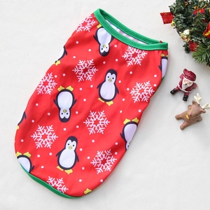 Dettaglio in piano di un gilet natalizio rosso per animali con stampa di pinguini e bordi verdi