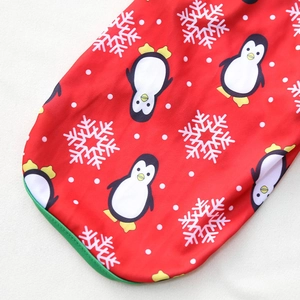 Dettaglio del gilet natalizio per animali con fiocchi di neve e stampe di pinguini