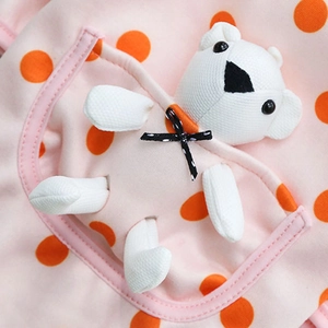Detail of pink dog sweater with orange polka dots and a cute 3D plush bear on pocket