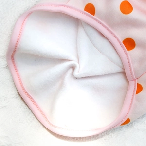 Close-up of the soft white faux shearling lining on the pink polka dot pet clothes