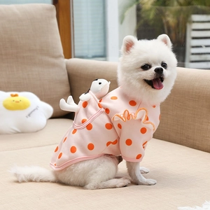Close-up of pink polka dot pet sweater with plush charm and ruffled orange edges