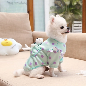 Detail of mint green polka dot dog sweater with ruffles and a cute plush bear in the pocket