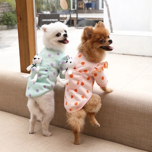 Close-up of cute polka dot pet sweaters with ruffle sleeves and plush toy pockets
