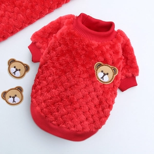 Detail of red plush dog sweater featuring warm fleece texture and cute bear embroidery