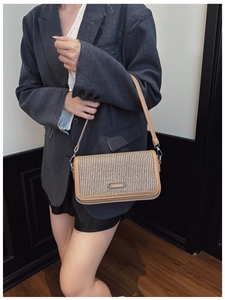 Detail of vintage crossbody bag showing beige woven texture and brown leather strap