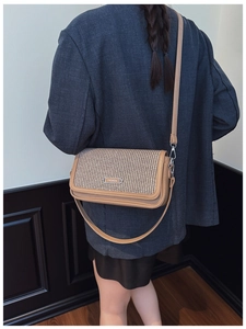 Detail view of the vintage crossbody bag showing woven texture and adjustable strap
