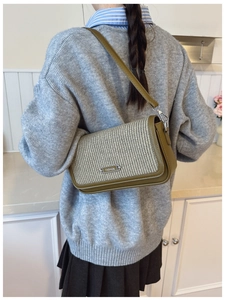 Detail of vintage crossbody bag with green leather, woven fabric and metal buckle