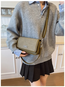 Detail of olive green leather and beige woven texture on a vintage crossbody bag