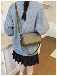 Detail of vintage crossbody bag in olive leather and beige weave on a model