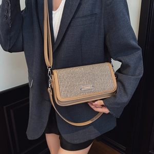 Minimalist woven flap crossbody bag with brown leather trim and metal fashion logo charm