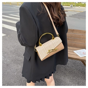Detail of premium PU leather handbag featuring woven beige flap and gold metal handle