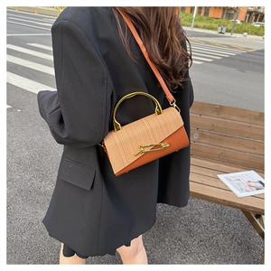 Close-up of a luxury PU leather crossbody bag featuring contrast stitching and gold handle