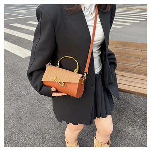 Detail view of brown PU leather and woven texture mix bag with gold metal handle