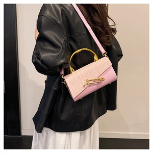 Detail of pink PU leather box bag featuring a woven texture flap and golden semicircular handle
