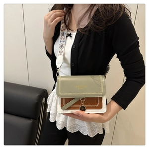Dettaglio borsa a tracolla color-block con ampia tracolla ricamata su modella