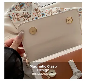Dettaglio della chiusura magnetica della borsa a tracolla bicolore con spallina larga