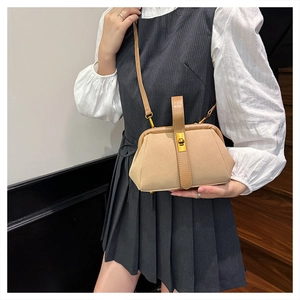 Detail of elegant beige shell bag featuring golden twist lock and leather shoulder strap