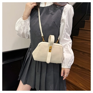 Chic beige matte shell bag shown with adjustable shoulder strap on a model outfit