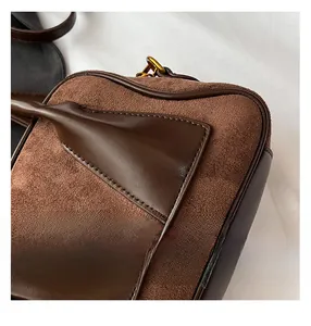 Close-up of brown frosted suede Boston bag with premium stitching and gold hardware detail