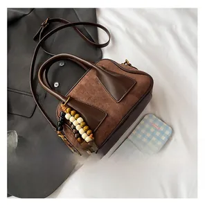 Detail view of vintage contrast color Boston bag with beaded tassel and suede texture