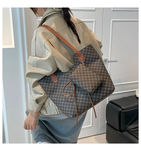 Détail du sac cabas à motif vintage avec anses en cuir et mini pochette attachée