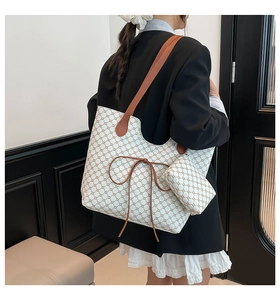 Détail du sac cabas à motif avec nœud en cuir et petit porte-monnaie assorti