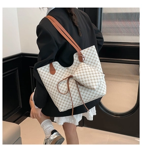 Détail du cabas imprimé avec pochette assortie et lanière en cuir marron porté
