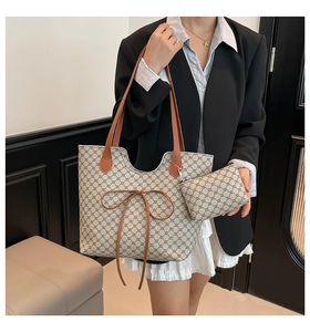 Détail du sac cabas beige avec motif floral et noeud décoratif en cuir marron