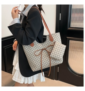 Détail du cabas imprimé avec nœud en cuir et mini pochette assortie incluse