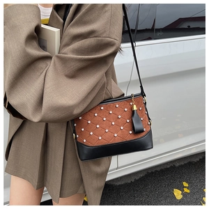 Detail of hobo bucket bag with brown suede patchwork, diamond rhinestones and tassels