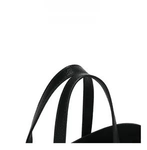 Dettaglio dei comodi doppi manici su una borsa tote in pelle nera a grana fine