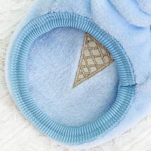 Dettaglio del gilet in peluche azzurro per animali con ricami dorati e bordo a coste