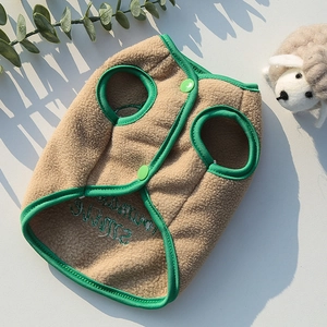 Close-up of khaki plush pet vest with green contrast trim and Warm Smile embroidery