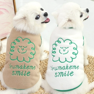 Two Pomeranians wearing soft fleece pet vests with smiling cloud embroidery in a cozy home