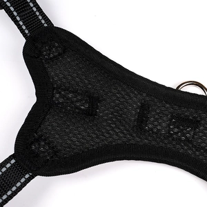 Close-up of black breathable mesh dog harness with reflective strips and metal D-ring