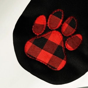 Close-up of red and black buffalo plaid paw print embroidery on black pet hoodie
