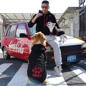 Owner and pet matching black hoodies with buffalo plaid paw prints for winter