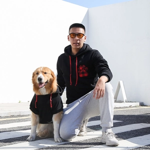 Matching black hoodies with red buffalo plaid paw prints for pet owners and dogs outdoors