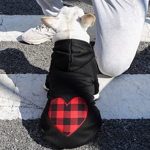 Detail of pet hoodie featuring a large red plaid heart patch on black knit fabric