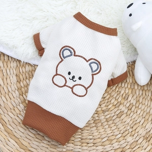Détail de la texture gaufrée et de la broderie ours sur le pull crème pour animaux