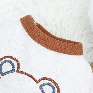 Détail de chemise pour animaux en maille gaufrée blanche avec col marron et broderie