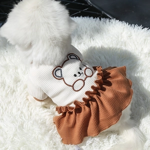 Détail d'une robe pour animaux avec maille gaufrée, jupe plissée et broderie ours