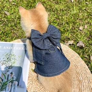 Close-up of denim pet harness featuring a large bow and sturdy metal D-ring for leash attachment