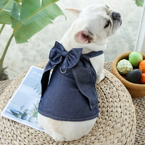 Detail of denim pet dress featuring a large bow and a metal D-ring for leash attachment